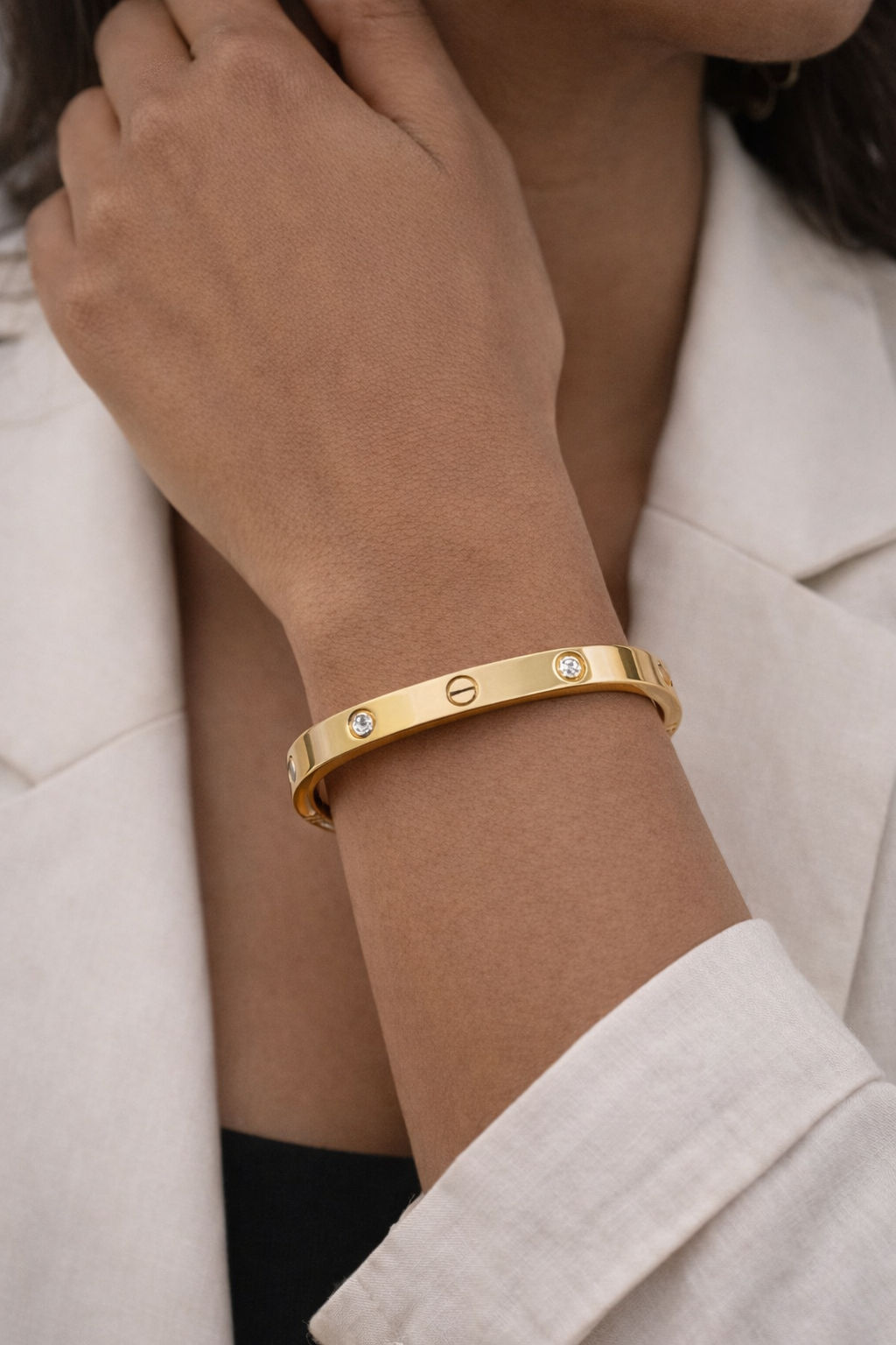 Anti-Tarnish, Ashaarya, Ashaarya Jewels, Ashaarya Jewellery, Gold bracelet with small stones on a person's wrist, wearing a light-colored coat.