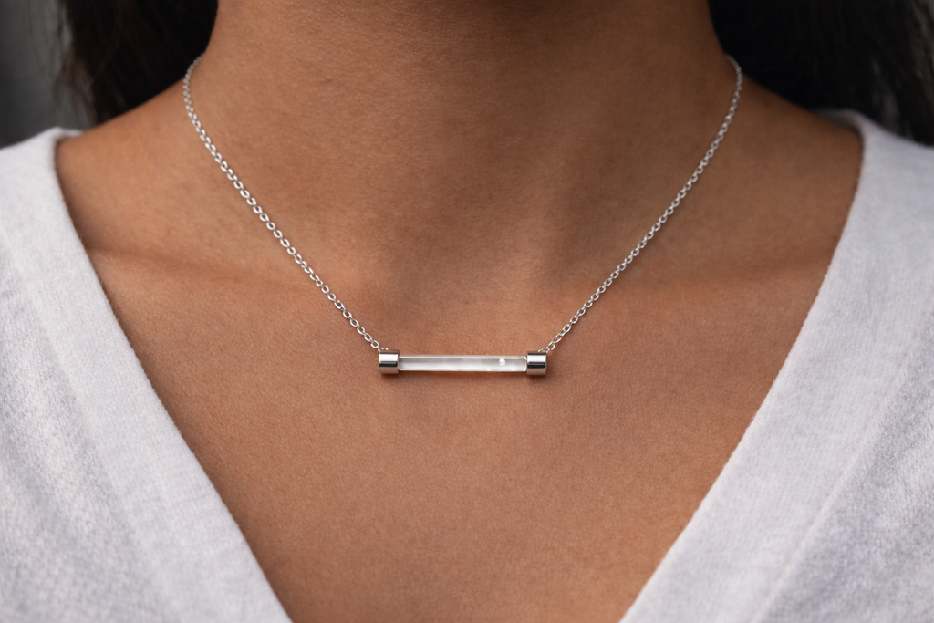 Ashaarya, Ashaarya Jewels, Ashaarya Jewellery, Silver necklace with a bar pendant on a person wearing a white top.