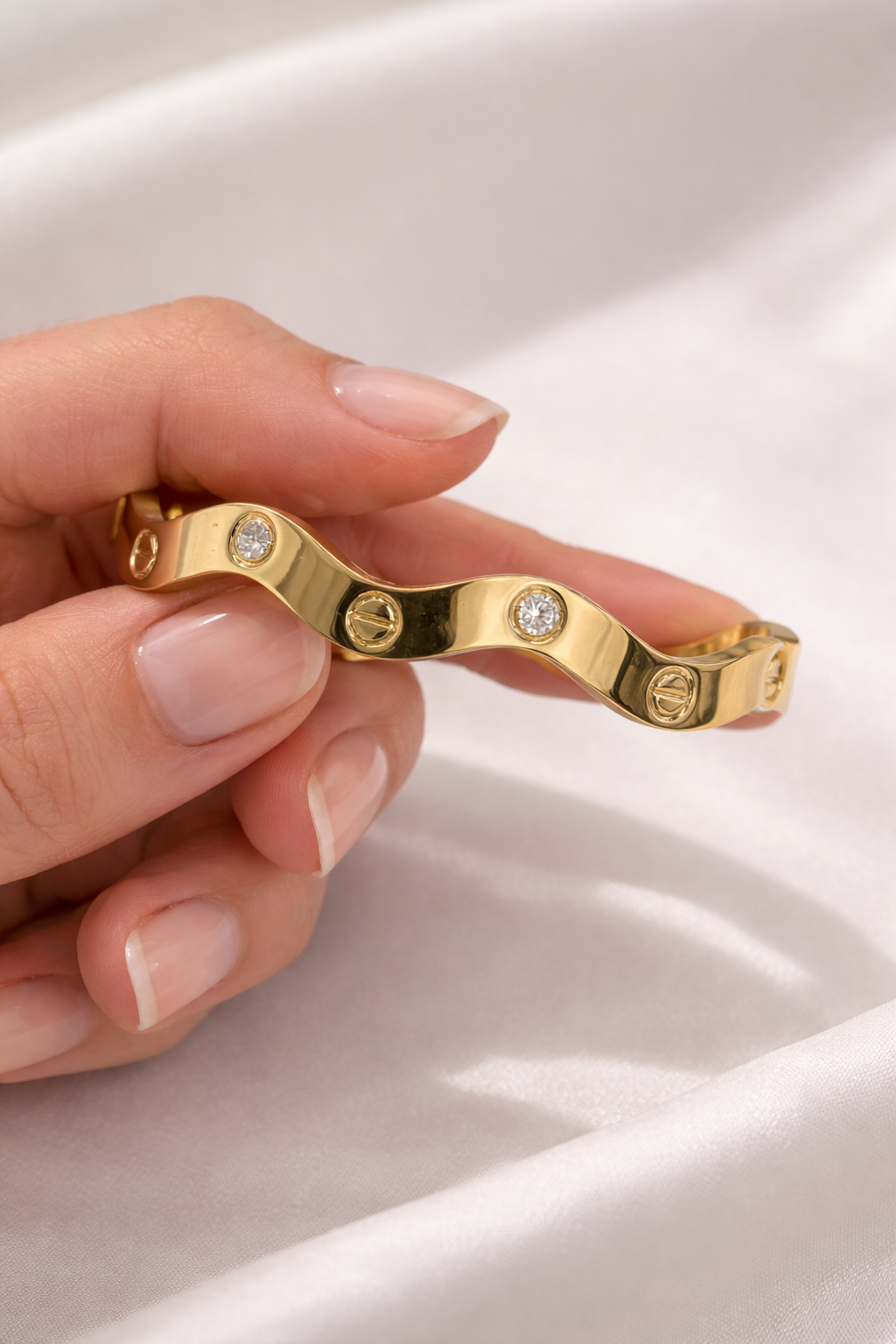 Anti-Tarnish, Ashaarya, Ashaarya Jewels, Ashaarya Jewellery, Gold bracelet with diamond accents held by a hand on a light background