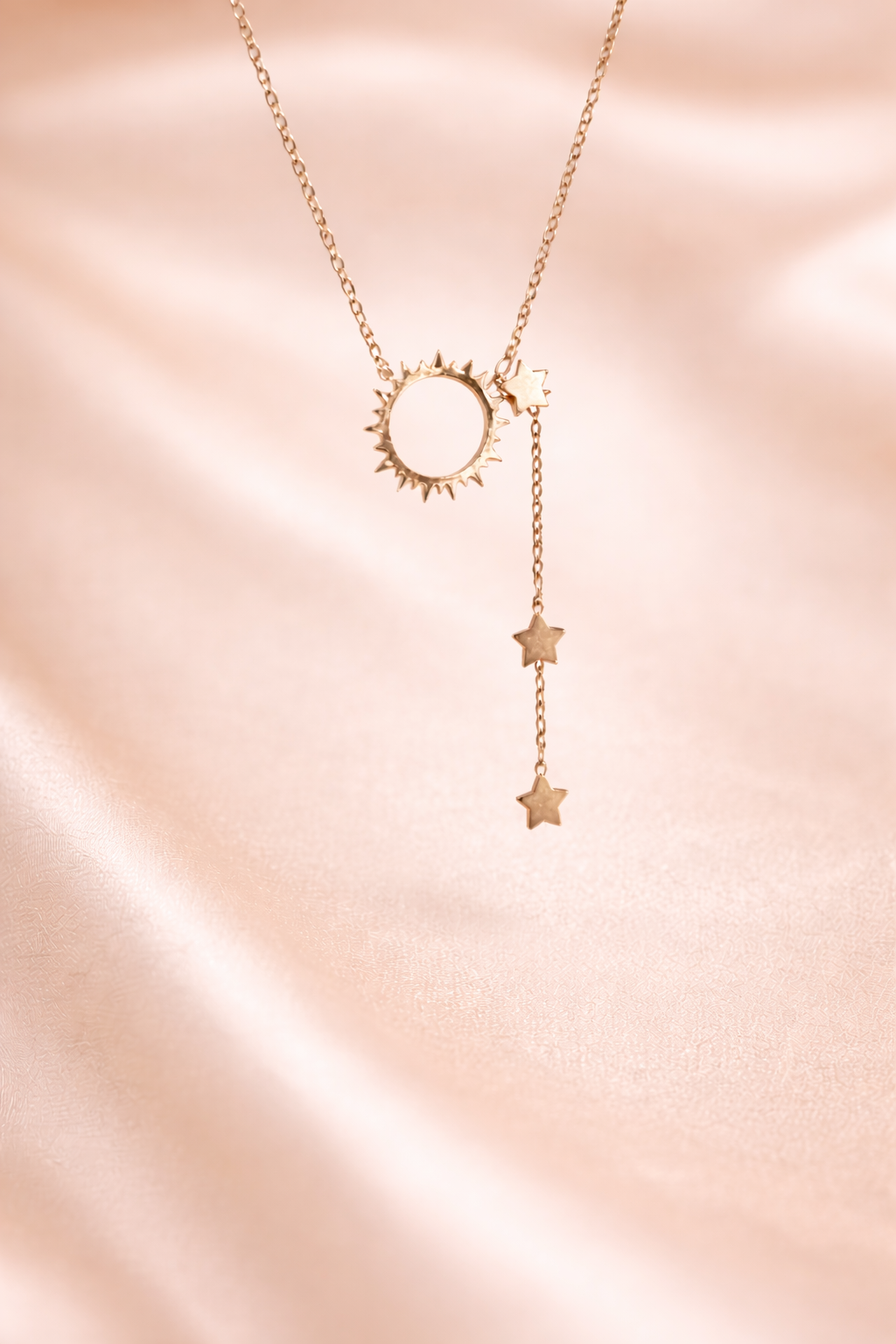 Anti Tarnish Necklace, Ashaarya, Ashaarya Jewels, Ashaarya jewellery, Rose gold necklace with sun and star pendants on a pink satin background