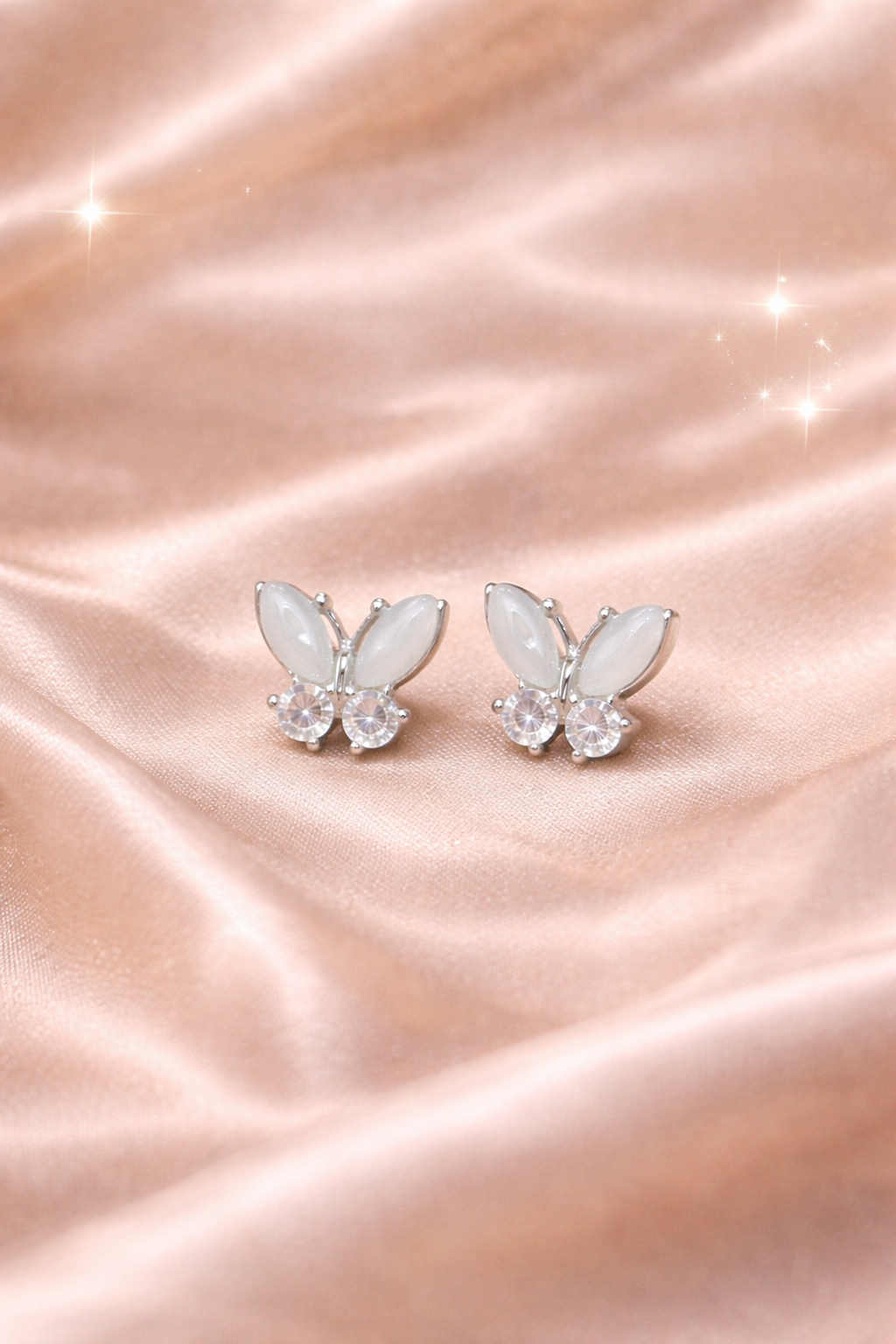 Ashaarya, Ashaarya Jewels, Ashaarya Jewellery, Butterfly-shaped earrings on a pink satin background