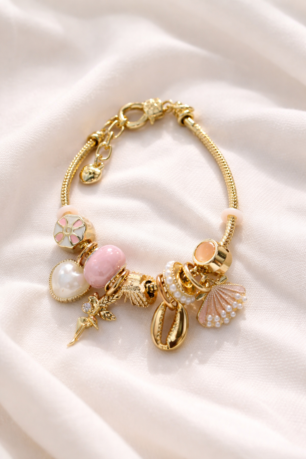 Anti-Tarnish, Ashaarya, Ashaarya Jewels, Ashaarya Jewellery, Gold bracelet with various charms on a white fabric background