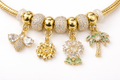 Anti-tarnish charm bracelet for women with butterfly, flower and palm charms in 18KT gold tone with American diamonds – comfort jewellery by Ashaarya