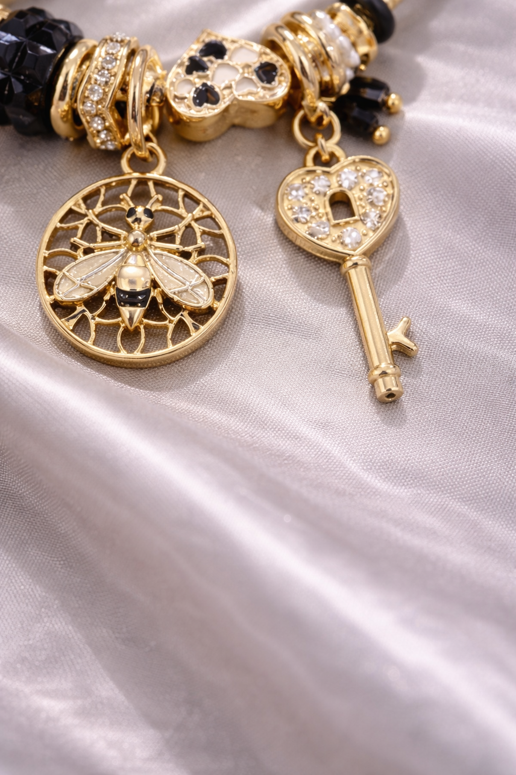 Anti-tarnish charm bracelets for women by Ashaarya featuring bee charm, heart lock key charm, black crystal beads and pearl accents designed as comfort jewellery.