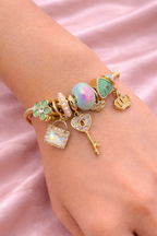 Anti-tarnish charm bracelets for women with green clover, opal bead and crown charms in gold plated demi-fine comfort jewellery by Ashaarya.