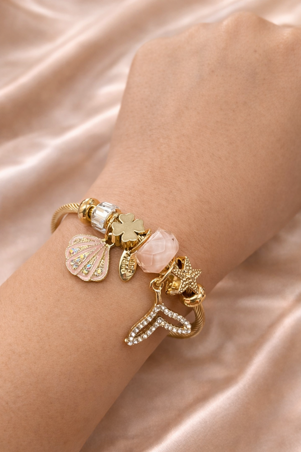 Anti-tarnish charm bracelets for women by Ashaarya featuring ocean inspired charms including shell, clover, rose quartz bead, starfish and mermaid tail in comfort jewellery design.