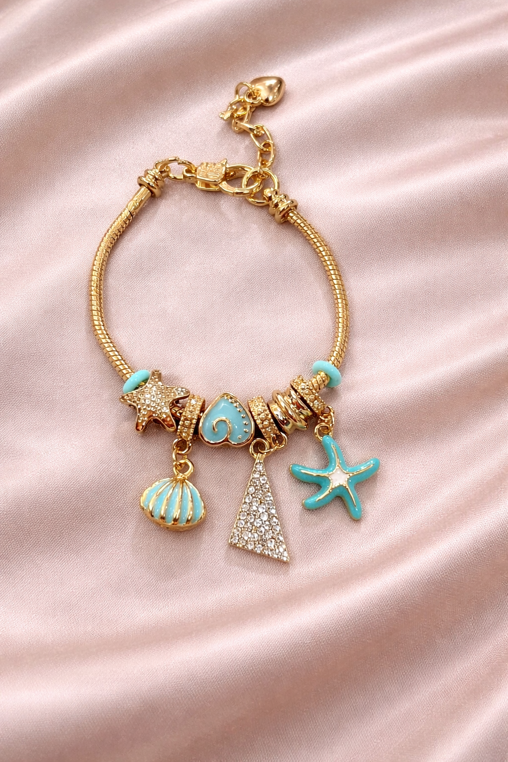 Anti-tarnish charm bracelets for women by Ashaarya, ocean inspired demi-fine charm bracelet with turquoise starfish and seashell charms, lightweight comfort jewellery.
