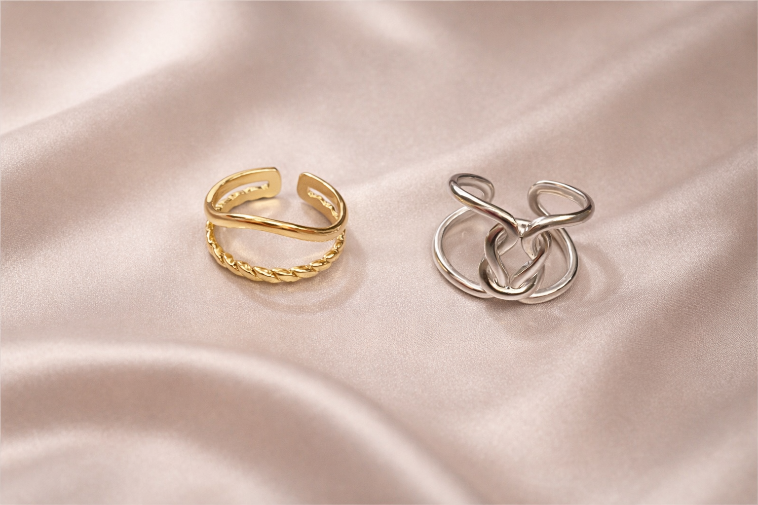 Anti-tarnish gold and silver duo ring stack worn on hand — adjustable comfort jewellery featuring twisted band and knot design, band rings for women, statement rings for women. Two gold and silver rings on a soft pink fabric background