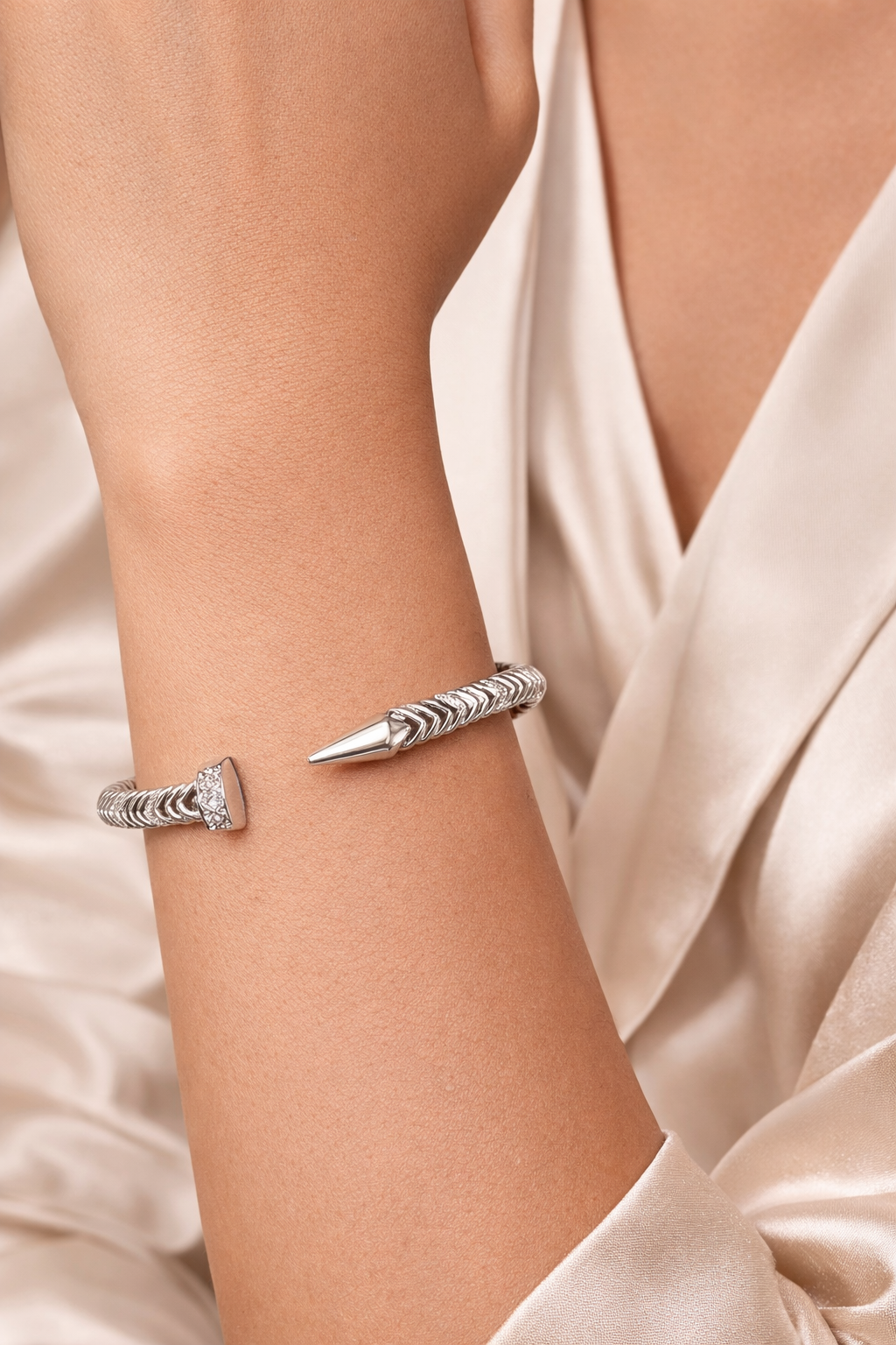 Hand shot of anti-tarnish nail bracelet for women worn on wrist showcasing lightweight comfort jewellery design by Ashaarya.Anti-tarnish nail bracelet for women from Ashaarya comfort jewellery collection featuring American diamond studded twisted nail design.