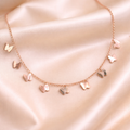 Anti Tarnish necklace, charm bracelets, ashaarya, ashaarya jewels, ashaarya jewellery, Rose gold necklace with heart-shaped pendants on a soft pink fabric background