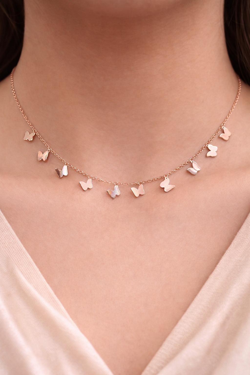 Anti Tarnish necklace, charm bracelets, ashaarya, ashaarya jewels, ashaarya jewellery, Rose gold butterfly necklace on a person wearing a light pink top