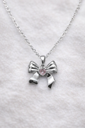 Anti tarnish necklace, Ashaarya, Charm bracelets, Ashaarya Jewels, Ashaarya jewellery, Silver bow-shaped pendant with a pink heart on a white background