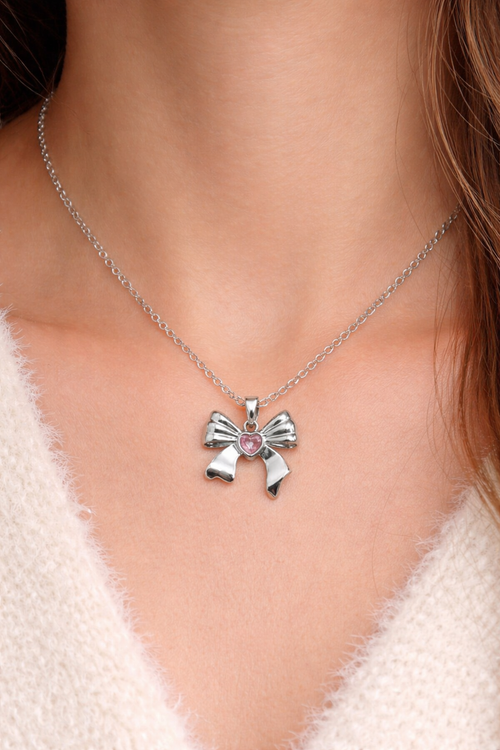 Anti tarnish necklace, Ashaarya, Charm bracelets, Ashaarya Jewels, Ashaarya jewellery, Necklace with a bow-shaped pendant worn by a person