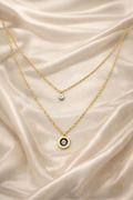 dual layer, anti tarnish, ashaarya, ashaarya jewels, ashaarya jewellery, charm bracletes, Two gold necklaces with pendants on a beige satin background