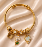Golden Bloom Charm Bracelet by Ashaarya featuring butterfly, rose, floral and opal heart charms in an 18KT gold tone finish.