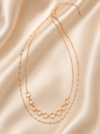 A delicate rose gold double-layer necklace with one chain featuring small hexagonal links and the other a fine chain, displayed on a draped beige satin fabric. rose gold necklace for women, dual layer necklace, layered necklace for women, geometric necklace, honeycomb necklace, minimalist necklace, rose gold jewellery, anti tarnish necklace, lightweight necklace, stainless steel necklace, everyday necklace, office wear necklace, dainty layered necklace, comfort jewellery, premium necklace for women, Ashaary