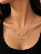 A close-up of a model's neck and chest wearing a delicate rose gold double-layer necklace. The top layer features a series of small, evenly spaced open circles, while the bottom layer is a fine beaded chain. rose gold necklace for women, dual layer necklace, layered necklace for women, geometric necklace, honeycomb necklace, minimalist necklace, rose gold jewellery, anti tarnish necklace, lightweight necklace, stainless steel necklace, everyday necklace, office wear necklace, dainty layered necklace, comfor