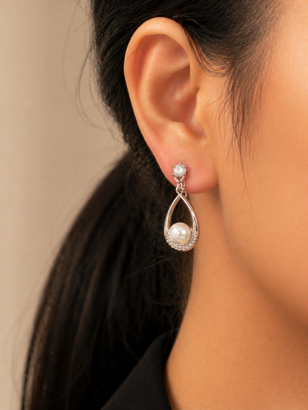 Lightweight pearl drop earrings for women with American diamond detailing, anti-tarnish comfort jewellery. Pearl earring worn by a person with a neutral background
