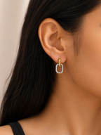 Close-up of an ear wearing a gold and silver hoop earring against a neutral background. two tone earrings, gold and silver earrings, stainless steel earrings, anti tarnish earrings, lightweight earrings, statement earrings for women, geometric earrings, modern earrings, link earrings, everyday earrings, skin friendly jewellery, comfort jewellery