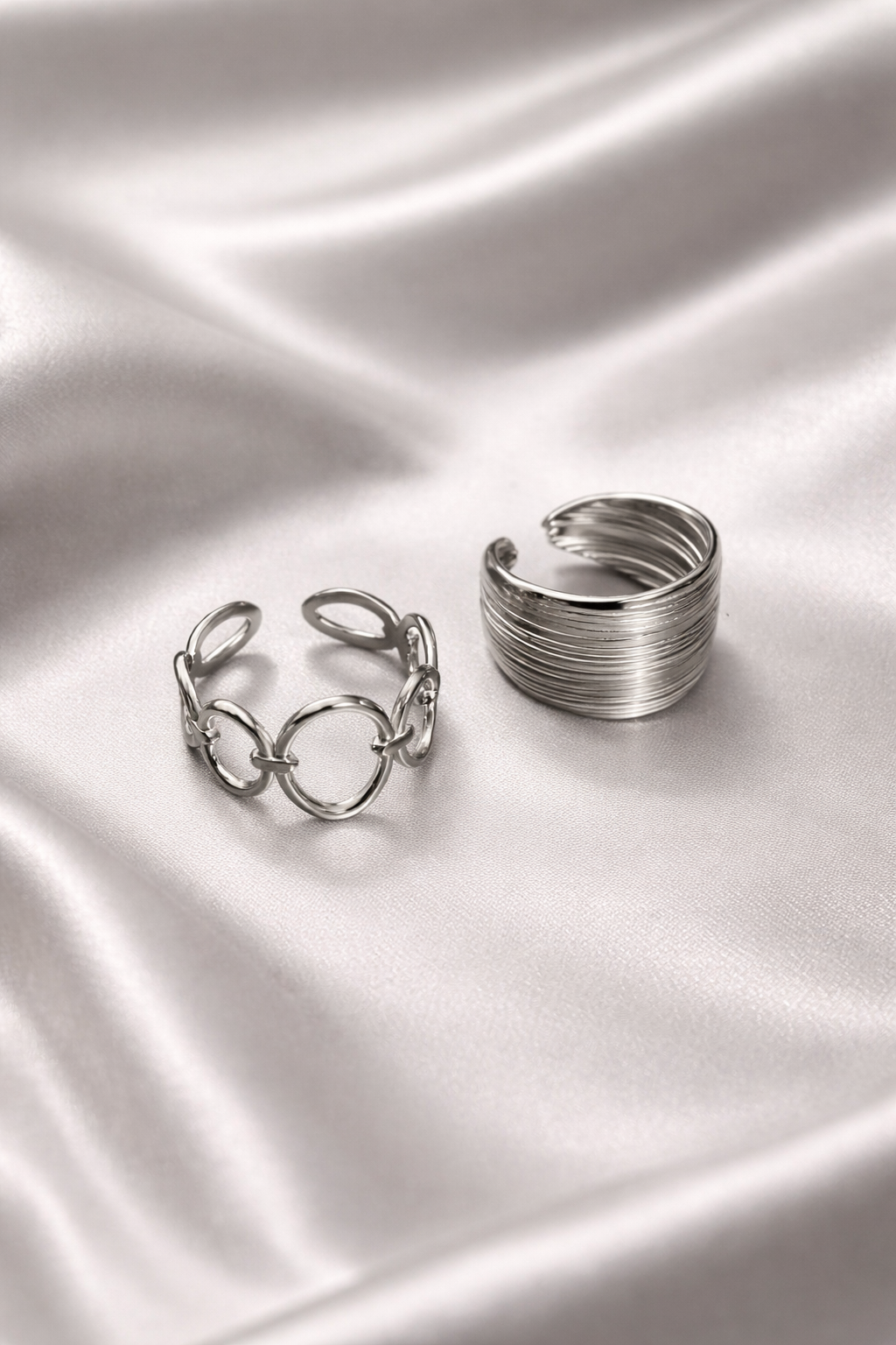 Anti-tarnish silver duo ring set featuring adjustable coil band ring and linked chain ring worn on hand – comfort jewellery silver rings for women, Two silver rings on a satin surface